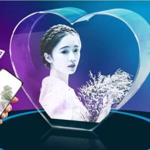 Heart-shaped glass art with a woman's portrait and nature scene.